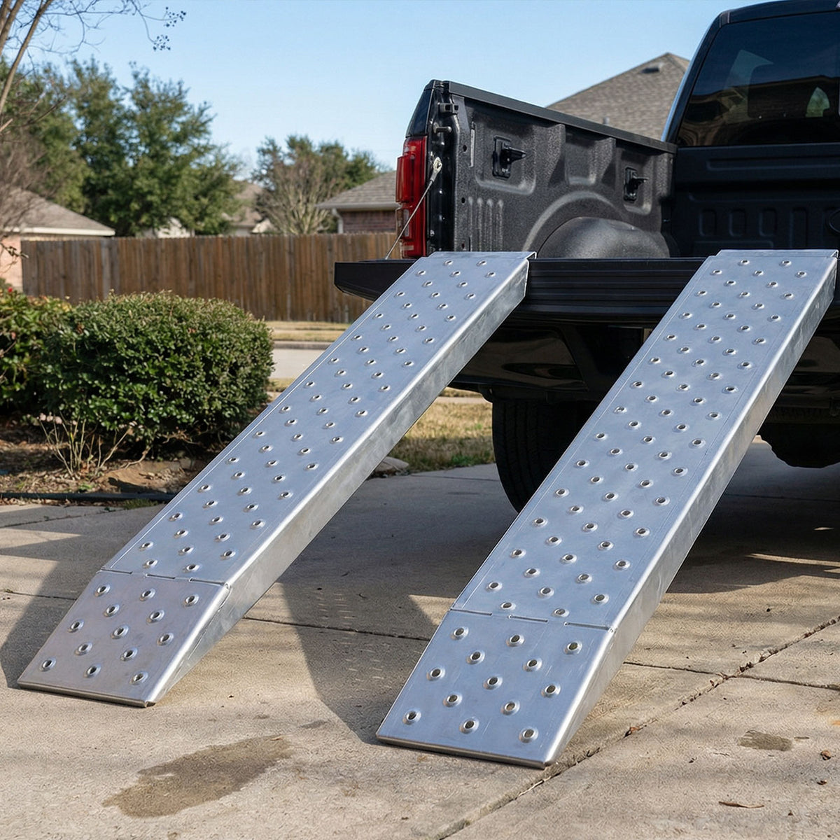 heavy-duty aluminum loading ramps positioned on a pickup truck bed