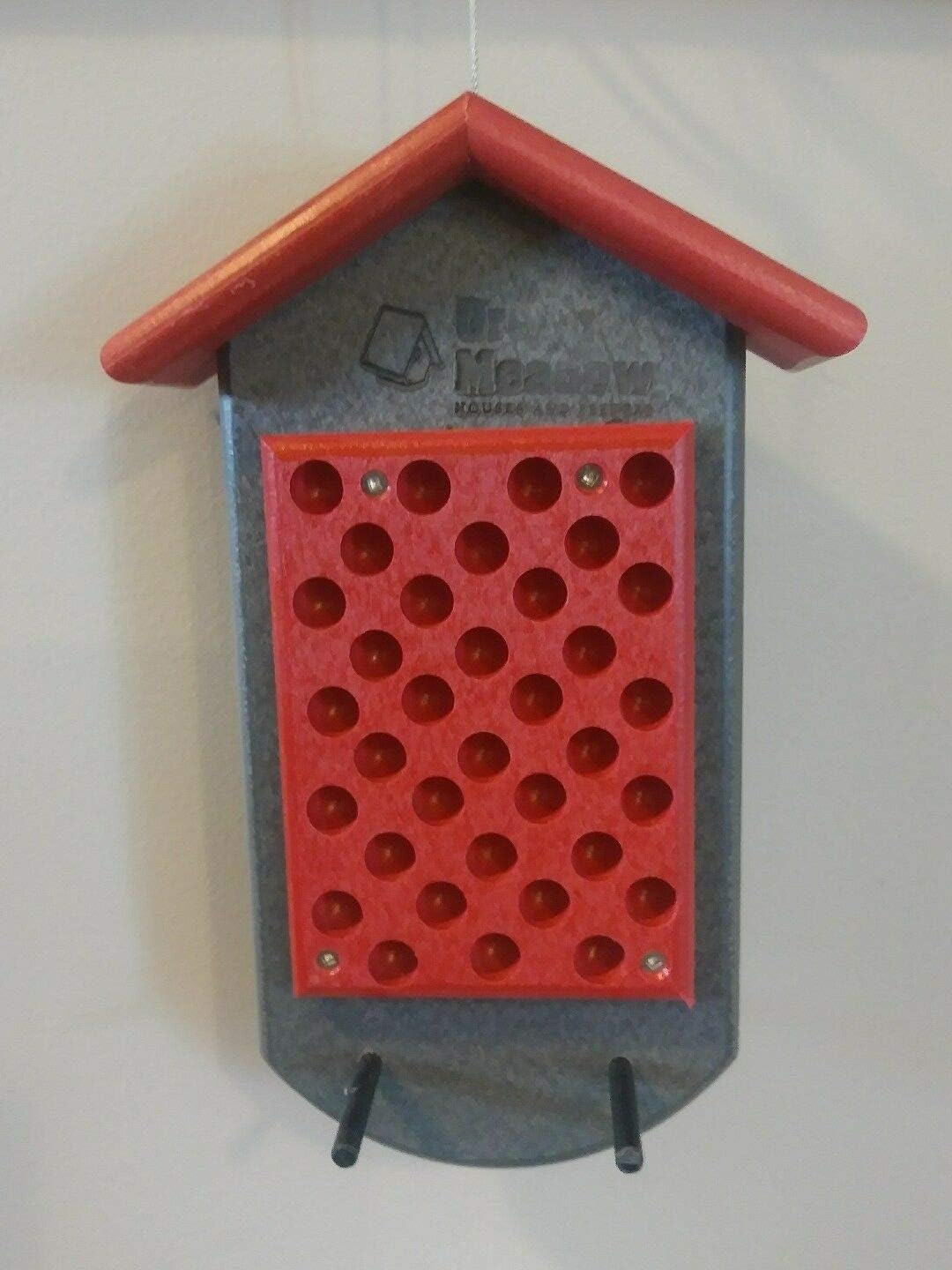 front view of peanut butter bird feeder with multiple feeding holes red/grey